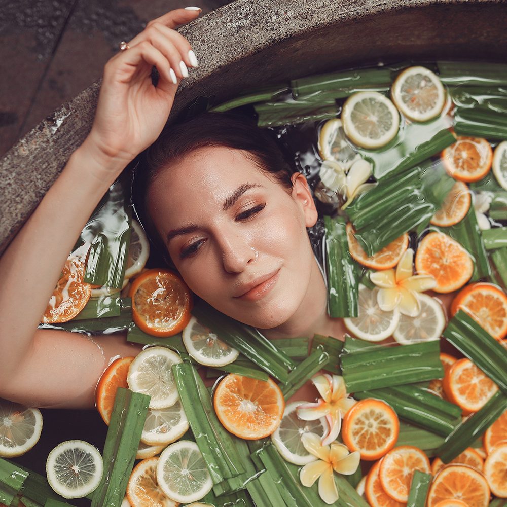 Girl in a bath. Lady on a Bali. Bath with fruits.